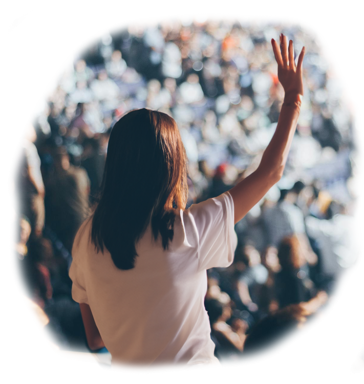 A woman raising her hand in a crowd